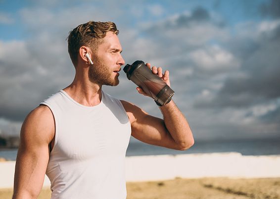 proteinshake-sportler-mit-trinkflasche-adobestock-933392756-3